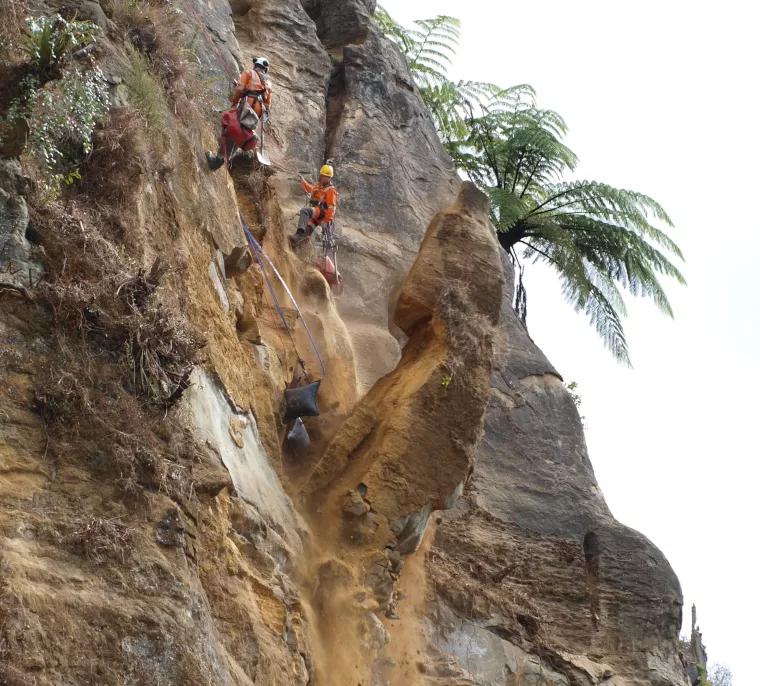 Avalon team members removing unstable rock from a cliff
